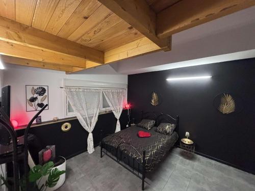 - une chambre avec un lit et un mur noir dans l'établissement Regal spa, à Calais