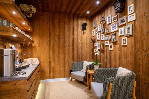 a kitchen with wooden walls and two chairs and a table at Hotel OTP Birkenhof in Bad Kleinkirchheim