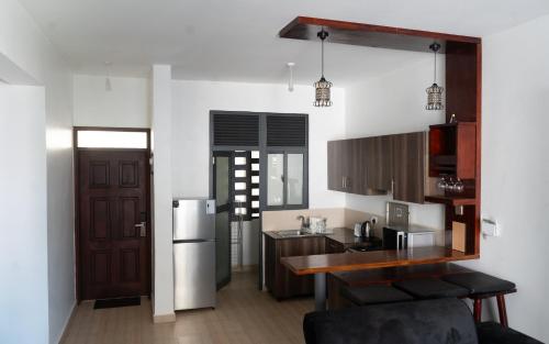 a kitchen with a table and a refrigerator at Comfortable Entebbe Condo by the Lake in Entebbe