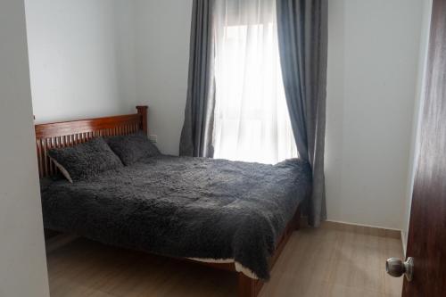 a bedroom with a bed and a window at Comfortable Entebbe Condo by the Lake in Entebbe