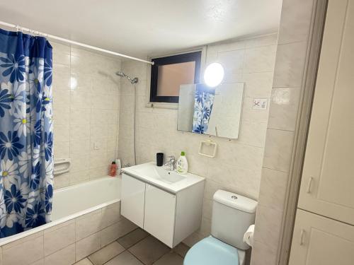 a bathroom with a toilet and a sink and a tub at Krasas Beach Apartments in Larnaka