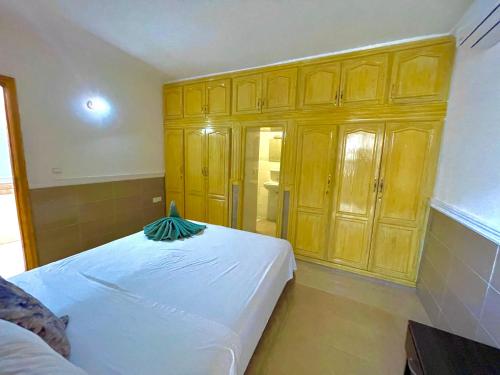 a bedroom with wooden cabinets and a white bed at Villa privée avec piscine Sans vis-à-vis, calme absolu in Marrakech