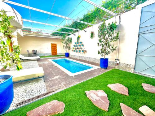 a swimming pool in a house with a green lawn at Villa privée avec piscine Sans vis-à-vis, calme absolu in Marrakech