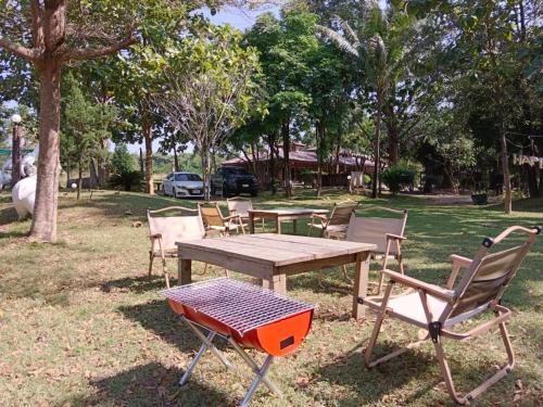 a picnic table and chairs in a park at Baan Varintorn Suanphueng in Suan Phung