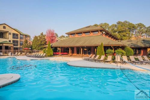 a pool at a resort with chairs and a building at Athens in Style! in Athens