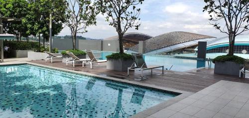 a large swimming pool with chairs next to a building at Emira Residence Seksyen 13 Shah Alam by Alpha LaVista in Shah Alam