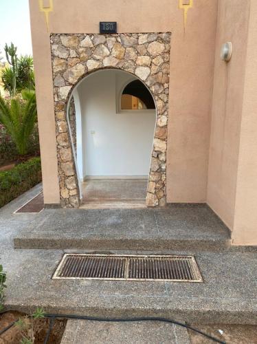 a building with a stone archway next to a drain at Villa Club Évasion vue sur mer in Tamellalt