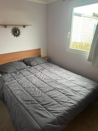 a bed in a bedroom with a window at MOBIL HOME Le Soleil,3CH,6PERS in Port-la-Nouvelle