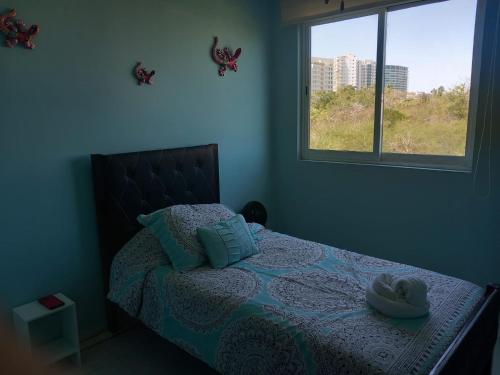 a bedroom with a bed with two hats on it at Perfectly located spacious apartment with 2 balconies in Ixtapa