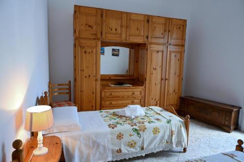 a bedroom with a bed and a wooden dresser at 'Largo Dei Sapori House' in Alberobello