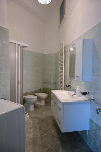 a bathroom with a sink and a toilet and a tub at 'Largo Dei Sapori House' in Alberobello