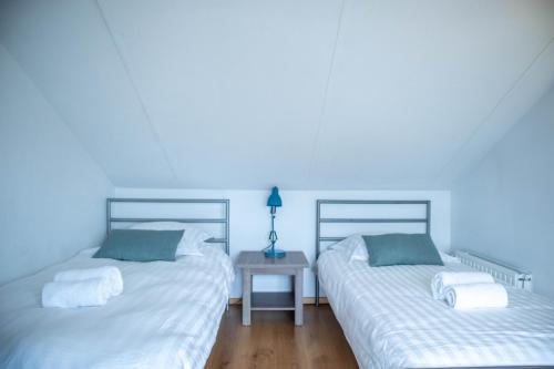 two beds sitting next to each other in a bedroom at Vakantiewoning Zee & Polder met tuin, dicht bij zee in Middelkerke