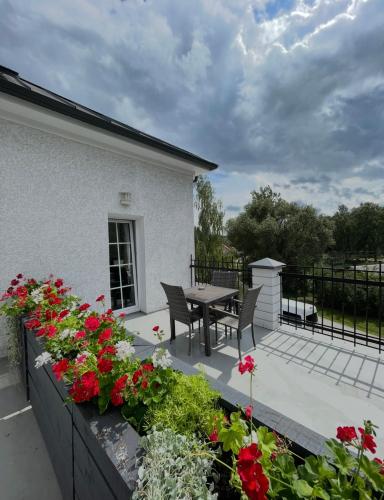 a patio with a table and chairs and flowers at La-Vanda in Šiauliai
