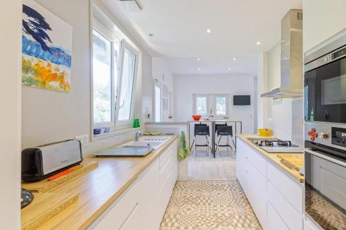 une cuisine avec des armoires blanches et un comptoir dans l'établissement LYS DE NOJALS - Superbe villa familiale entre lac et mer avec jardin, à Soorts-Hossegor