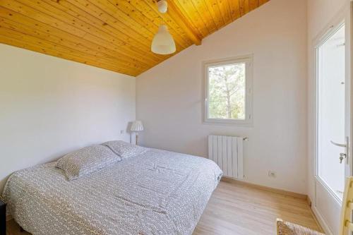 a bedroom with a bed and a window at LYS DE NOJALS - Superbe villa familiale entre lac et mer avec jardin in Soorts-Hossegor
