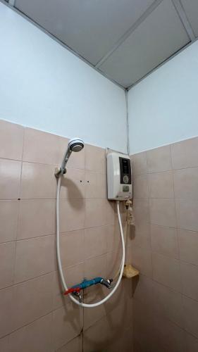 a shower in a bathroom with a hose on a wall at BB Sweet Home in Ban Hin Kong (1)