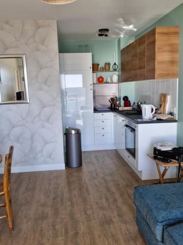 une cuisine avec des placards blancs et un canapé bleu dans l'établissement Vacances au rythme des marées, à La Turballe