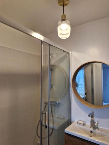 Un baño con ducha, lavabo y espejo. en Vacances au rythme des marées, en La Turballe