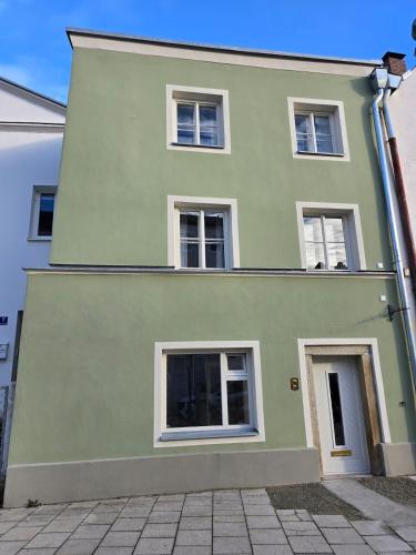 a green house with white windows on a street at Untere Vorstadt, Deggendorf in Deggendorf