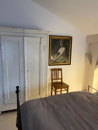 a bedroom with a painting on the wall and a chair at Untere Vorstadt, Deggendorf in Deggendorf