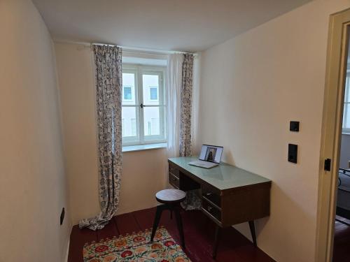 a room with a desk with a chair and a window at Untere Vorstadt, Deggendorf in Deggendorf