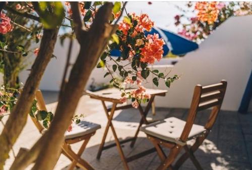 two chairs and a table with flowers on it at Casa Monki in Raposeira
