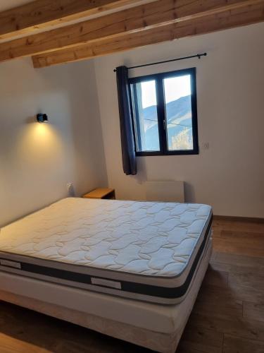 une chambre avec un lit dans une pièce avec une fenêtre dans l'établissement Maison l ouline, à Montferrer