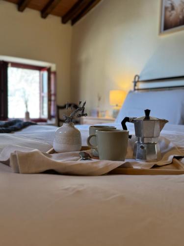 a bed with two cups and tea sets on it at Il Ginepro Home in Rosennano