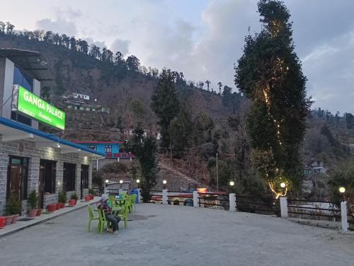 a person sitting at a gas station next to a mountain at ganga palace in Munsyari