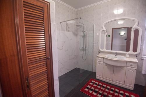 a bathroom with a shower and a sink and a mirror at Casa Gabriel Barbosa in Lagoa