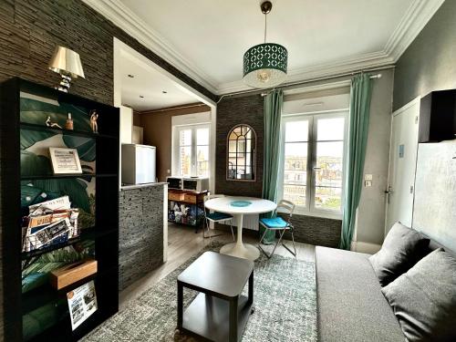 un salon avec un canapé et une table dans l'établissement joli T2 situé dans le coeur de Cabourg, à Cabourg