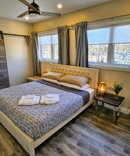 a bedroom with a bed with two towels on it at Redwood Suite in Niagara on the Lake
