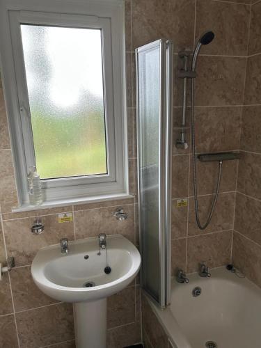 a bathroom with a sink and a shower with a window at 85 Strawberry Hill Hayle in Hayle