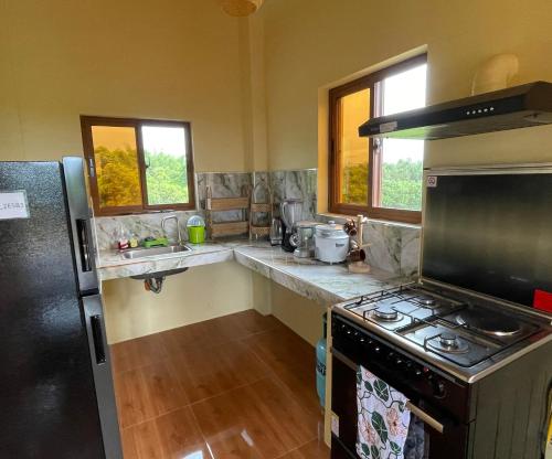a kitchen with a stove and a refrigerator at Balai Moca Hillside with Sunset View in San Juan