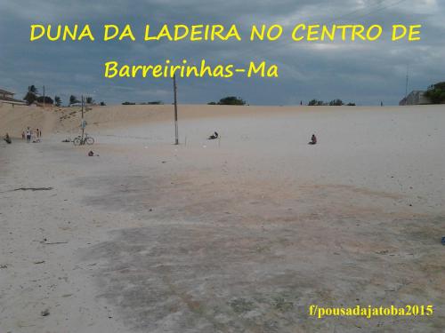 a beach with a sign that reads duna da lagrarra no centro at Pousada Jatobá in Barreirinhas