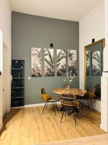 une salle à manger avec une table et quelques tableaux au mur dans l'établissement L'élégant duplex Carmes, à Toulouse