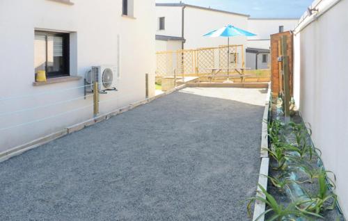 a patio with an umbrella next to a building at Nice Home In Clohars-Carnoët With Wifi in Clohars-Carnoët