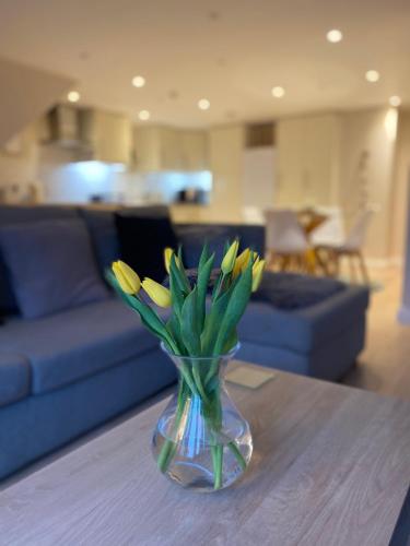 a vase of yellow flowers sitting on a table at The Workshop, Bridge House in Laxey