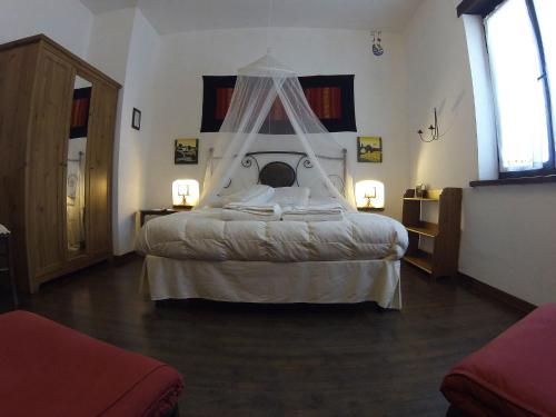 a bedroom with a large bed with a canopy at C'era Una Volta in Ripatransone