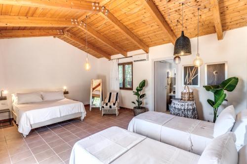 a bedroom with two beds in a room with wooden ceilings at Casale Giancesare Villa Agricola in Capaccio-Paestum
