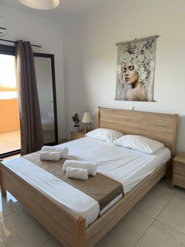 a bedroom with a large bed with two towels on it at Blue Sand Apartment in Analipsi