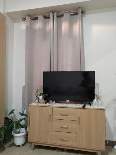a flat screen tv sitting on top of a wooden cabinet at Saint Honore Megaworld in Iloilo City