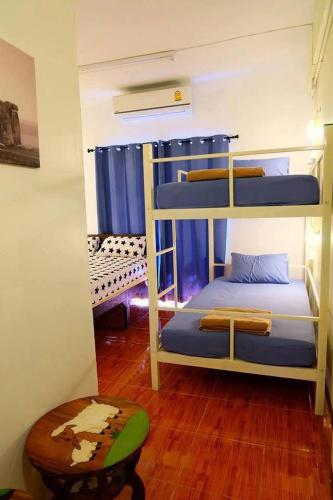 a room with three bunk beds and a wooden floor at Chiangmai by DD&B hostel in Chiang Mai