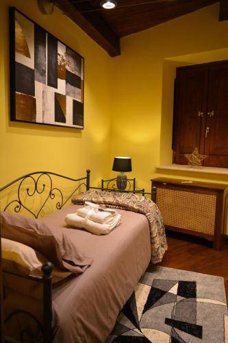 a yellow bedroom with a bed with towels on it at Domus Telesio Bed & Breakfast in Cosenza