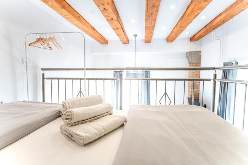 Un dormitorio con paredes blancas y techos de madera. en The Wonderful Loft, en Liubliana
