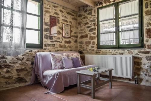a living room with a couch and a table at Orgon Farm Traditional Houses in Apóstoloi