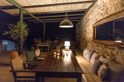 a living room with a table and a stone wall at Orgon Farm Traditional Houses in Apóstoloi