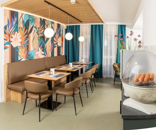 a restaurant with tables and chairs and a fish bowl at Cleverhotel in Herzogenburg