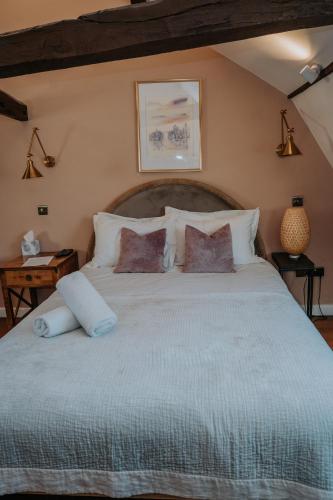 a bedroom with a large bed with white pillows at Rose & Star Cottage in Frome