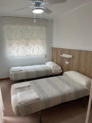 a bedroom with two beds and a ceiling fan at Apartamento CA VALEN 4 in Peniscola